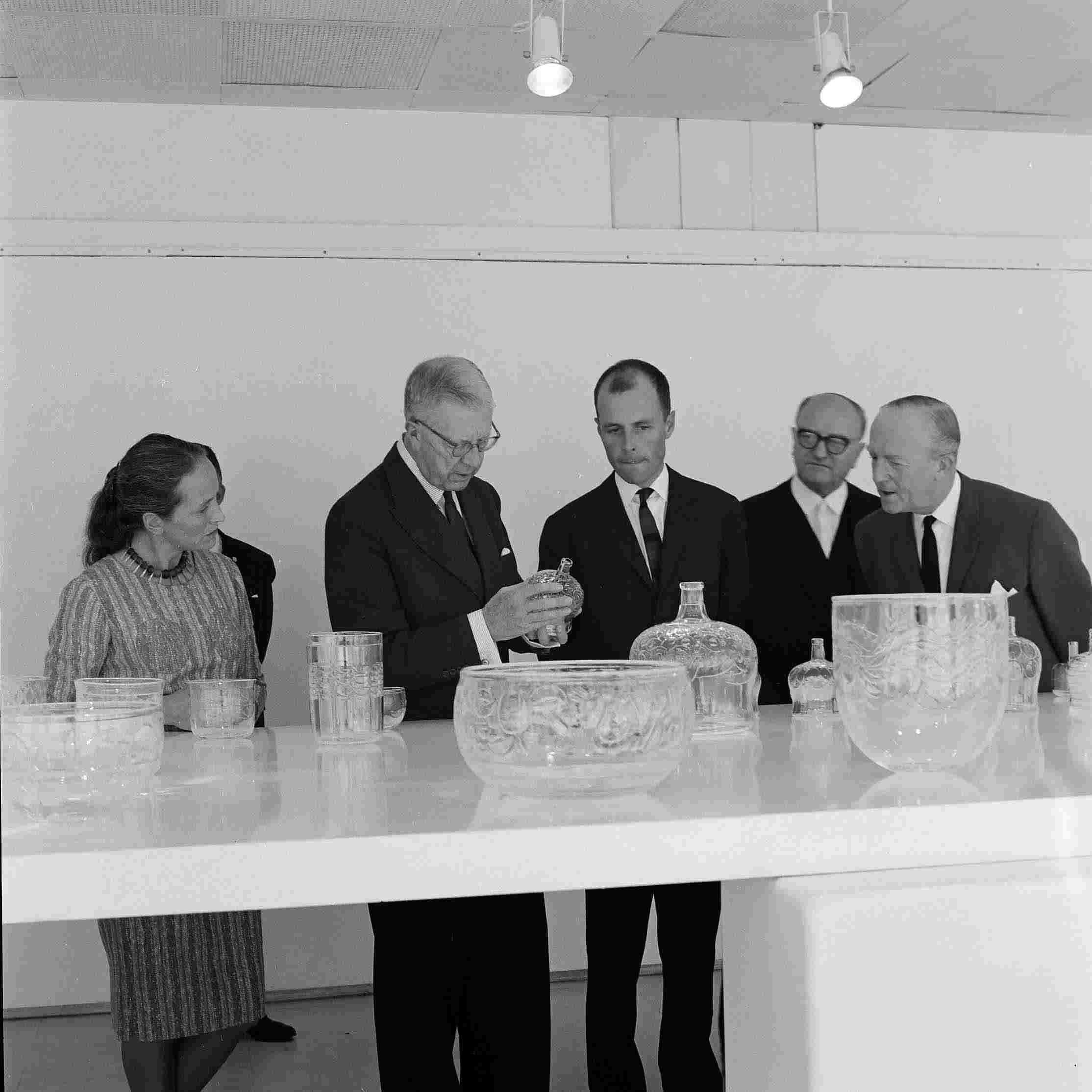 Fr v.  Ingeborg Lundin, Kung Gustav VI Adolf, Orrefors ägare och VD Johan Beyer, Rektor på Konstfackskolan Åke Stavenow samt okänd under visningen av utställningen Två Glas, 1963.